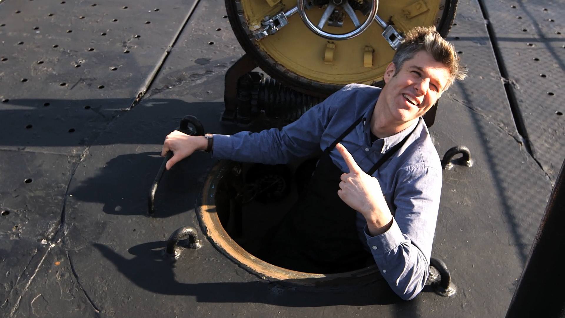 Man climbing out of a submarine escape hatch